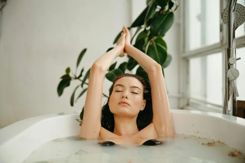 a woman taking a bath in a bathtub, inspired by Elsa Bleda, trending on pexels, renaissance, eucalyptus, hair floating covering chest, attractive pose, manuka