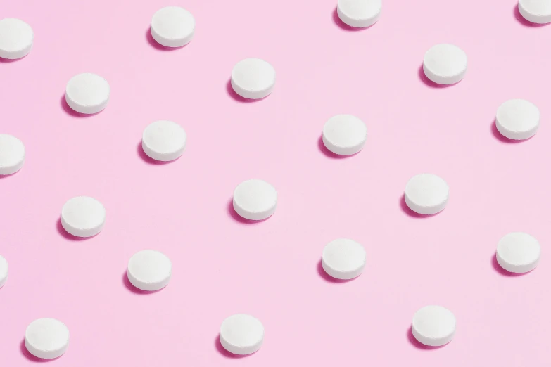 a lot of white pills on a pink background, trending on pexels, polkadots, trending on dezeen, panels, cosmopolitan