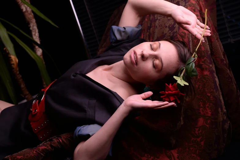 a woman laying on a couch with a flower in her hair, pexels contest winner, renaissance, black and red silk clothing, portrait image, closed limbo room, various posed