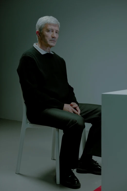a man sitting on top of a white chair, inspired by Bruce Nauman, unsplash, hyperrealism, patrick stewart, seated in court, promo image, ignant