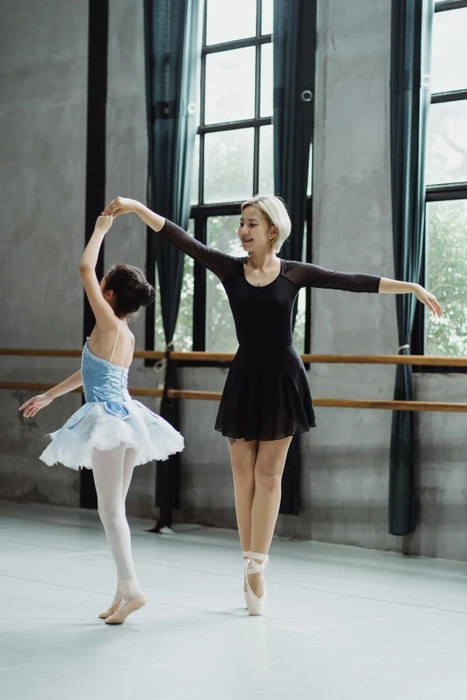 a couple of women that are standing in a room, arabesque, wearing a tutu, teaching, high quality upload, louise zhang