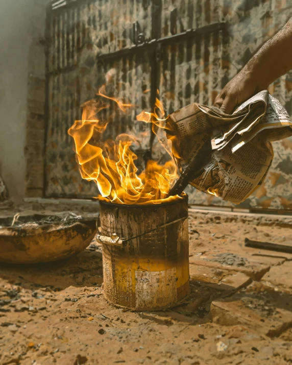 a person holding a tea kettle over a fire, pexels contest winner, process art, firing it into a building, chemically damaged, lgbtq, islamic