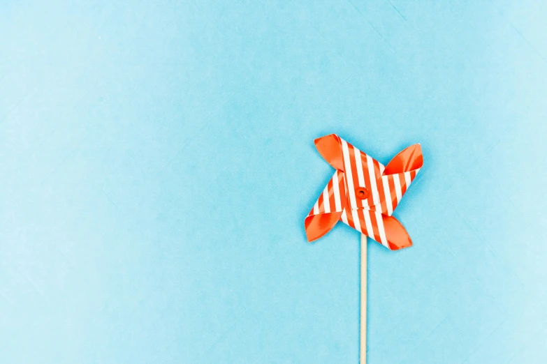 a red and white striped pinwheel on a stick, pexels contest winner, postminimalism, cyan and orange, paper cutout, thumbnail, flatlay