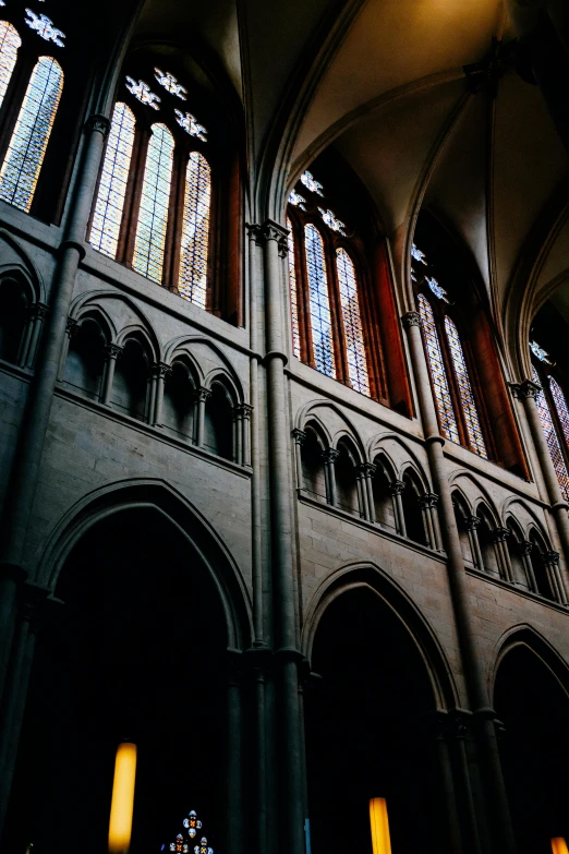 the interior of a cathedral with stained glass windows, an album cover, unsplash, romanesque, belgium, buttresses, muted coloures, 14th century