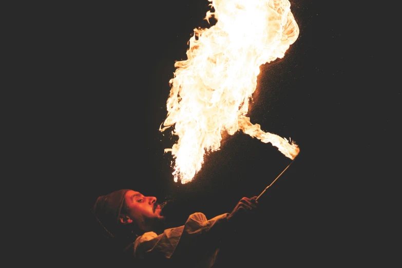 a man holding a stick in front of a fire, firebreathing, profile image, lit from above, lit from the side