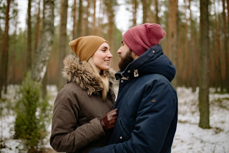 a man and woman standing next to each other in a forest, by Grytė Pintukaitė, pexels contest winner, wearing a beanie, warm friendly expression, avatar image, mid-twenties