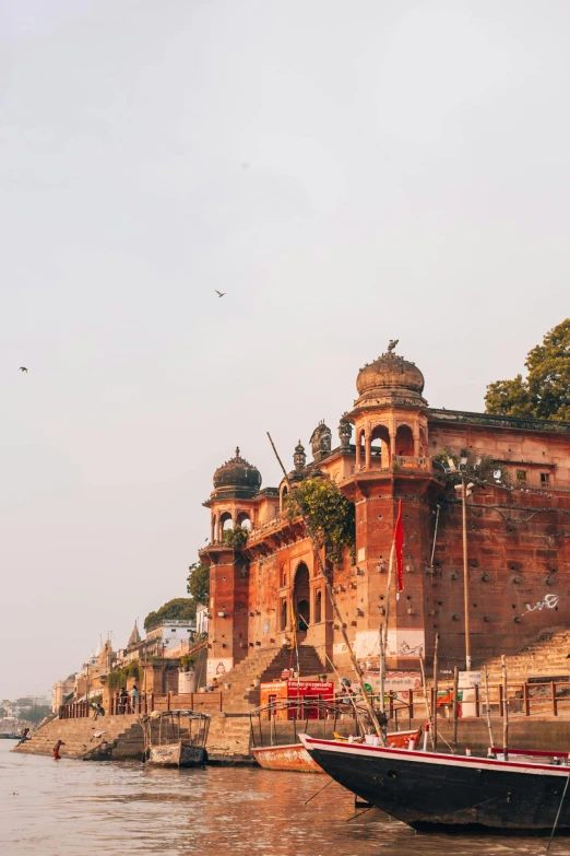 a boat that is sitting in the water, pink marble building, ancient india, surrounding the city, gateway