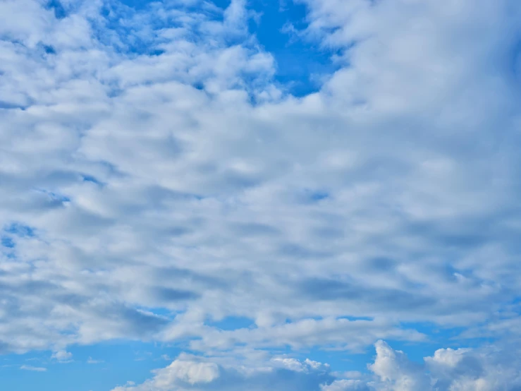 a man flying a kite on top of a lush green field, unsplash, minimalism, layered stratocumulus clouds, today\'s featured photograph 4k, sky blue, cumulus