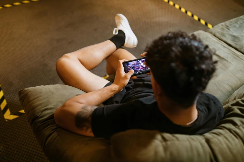 a man sitting on a couch using a cell phone, trending on pexels, pixel art, esports, laying down, body shot, shot from the back