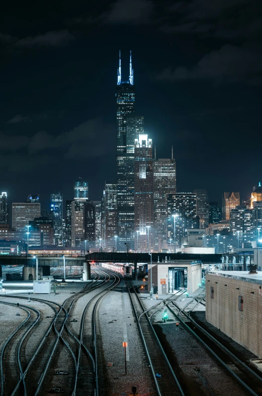 a train traveling through a city at night, by Chris Cold, unsplash contest winner, chicago skyline, stacked city, cold lighting, panoramic
