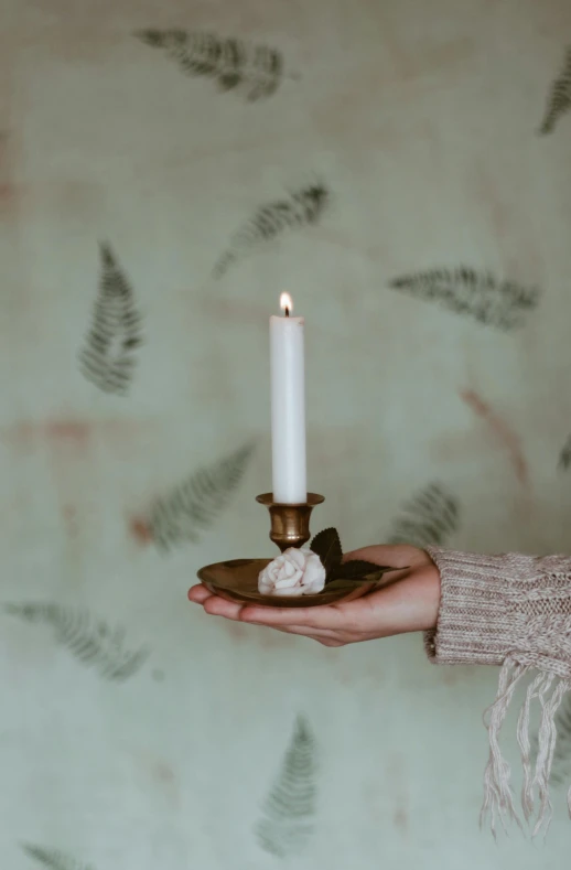 a person holding a candle in their hand, a marble sculpture, inspired by Elsa Bleda, baroque, hand built ceramics, botanicals, softly lit, brass and copper