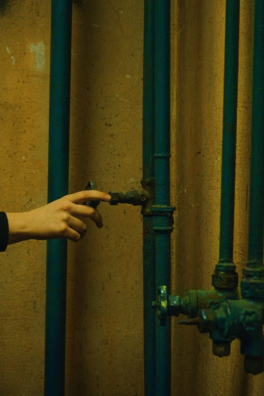 a close up of a person touching a pipe, inspired by Elsa Bleda, renaissance, moody : : wes anderson, wong kar wai, filmstill, maintenance