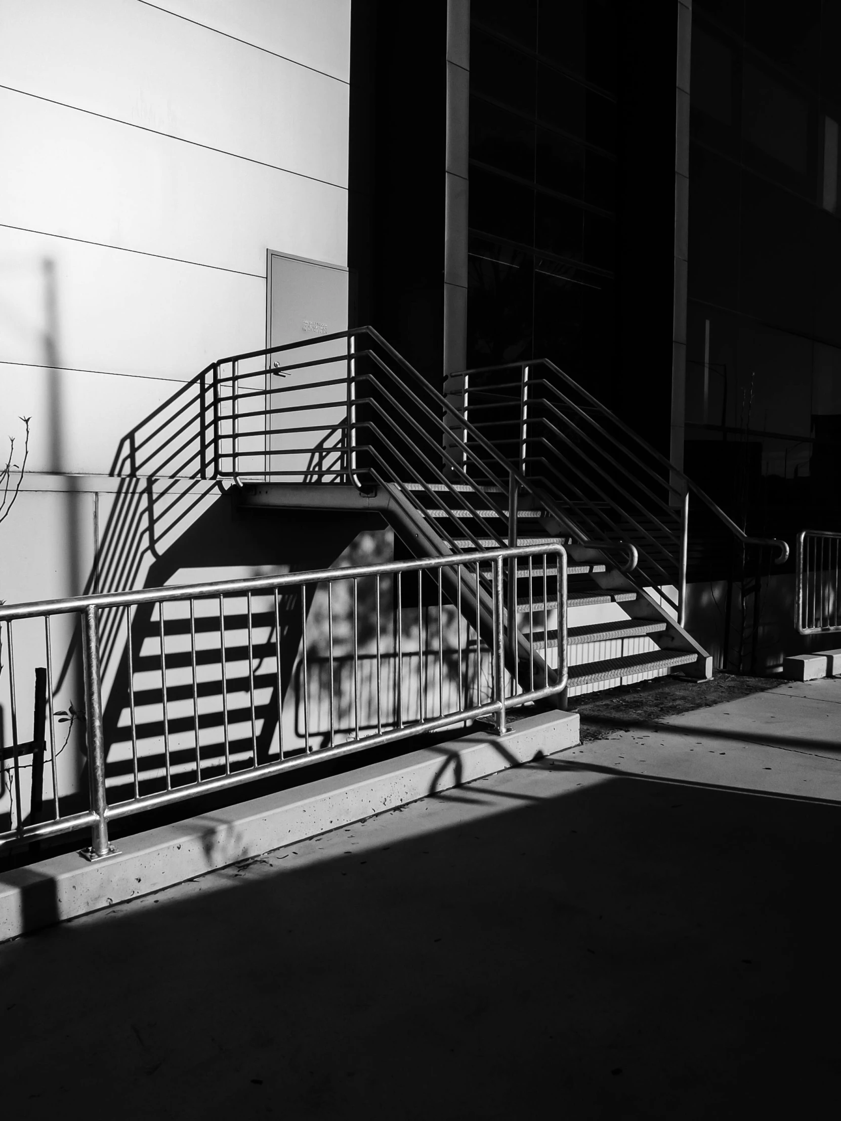 a man riding a skateboard up the side of a ramp, a black and white photo, by Michalis Oikonomou, stairs to an upper floor, set in tokyo bank parking lot, strong shadows), monochrome:-2