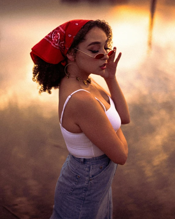 a woman in a red bandanna smokes a cigarette, inspired by Elsa Bleda, trending on pexels, ((sunset)), curls and curves, 1990s fashion, light skin