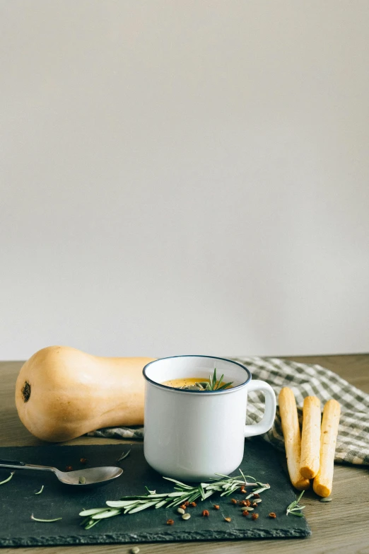 a bowl of soup sitting on top of a wooden table, a still life, by Everett Warner, unsplash, white mug, gourds, slate, high quality photo