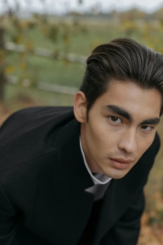 a man in a suit poses for a picture, an album cover, inspired by Zhang Han, trending on pexels, styled hair, christian, model face, fall