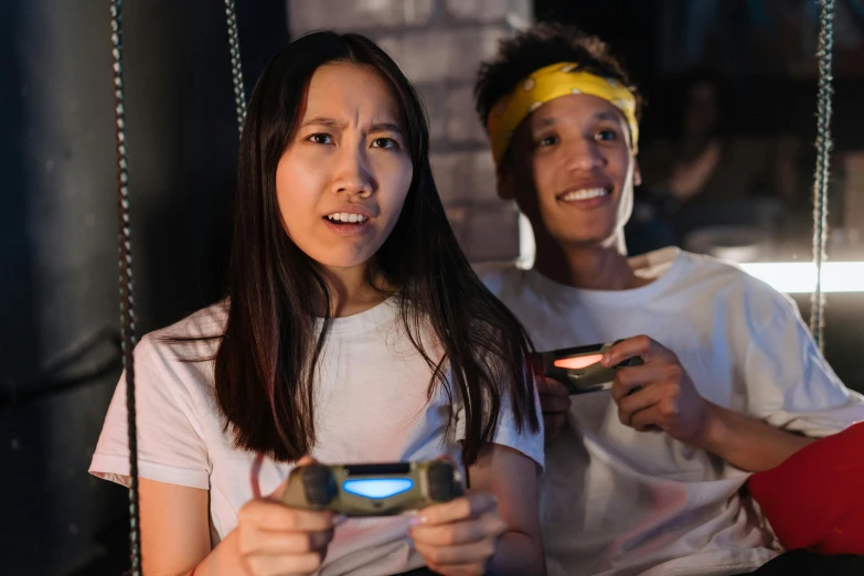 a couple of women sitting next to each other on a swing, pexels contest winner, realism, playing video games, star trek asian woman, nvidia promotional image, group of people in a dark room