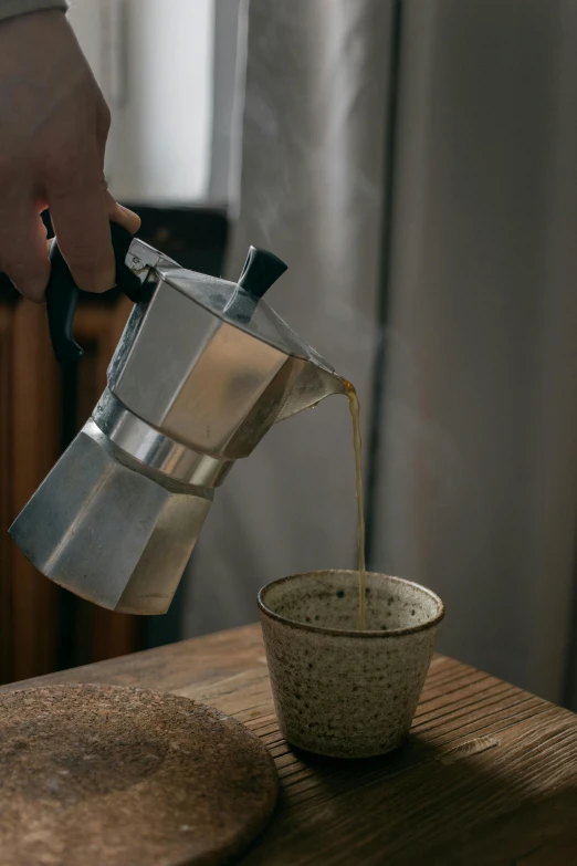 a person pouring coffee into a cup on a table, aluminum, medium height, alessio albi, eucalyptus