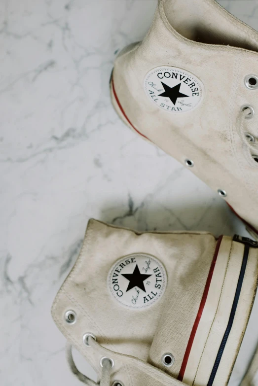 a pair of white sneakers sitting on top of a marble floor, trending on pexels, converse, beige colors, multiple stories, van