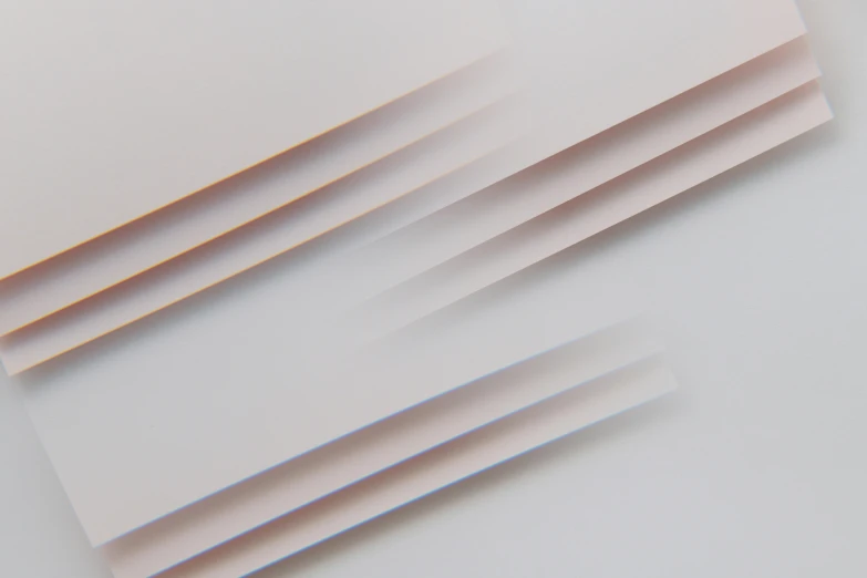 a close up of a sheet of paper on a table, an abstract drawing, unsplash, plasticien, gradient brown to white, stacked computer screens, plain background, light blush