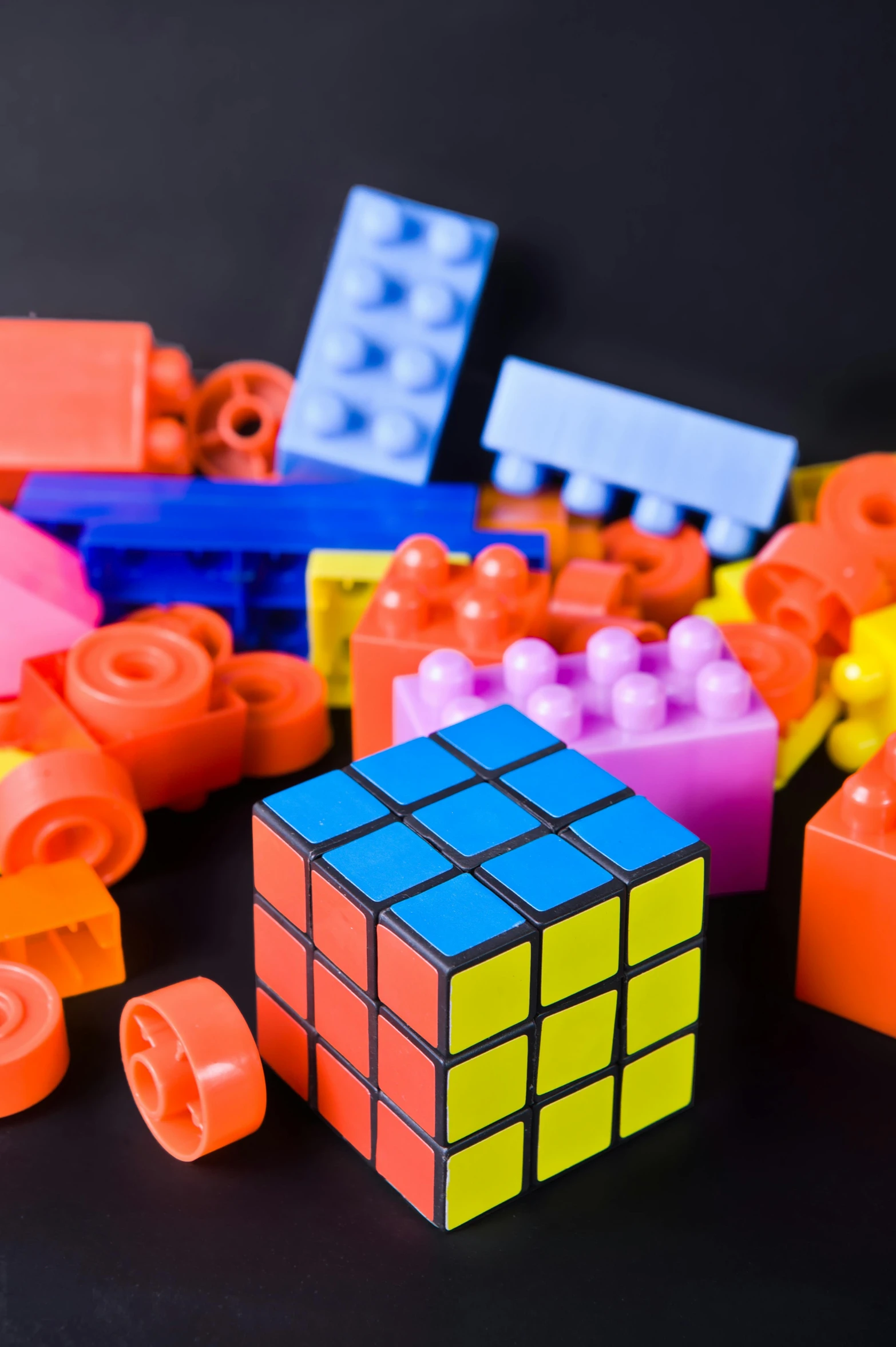 a pile of legos sitting on top of a table, a rubik's cube, geometrical figures, thumbnail, vivid)