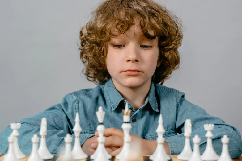 a young boy playing a game of chess, pexels contest winner, curls on top of his head, 15081959 21121991 01012000 4k, promotional image, facing forward