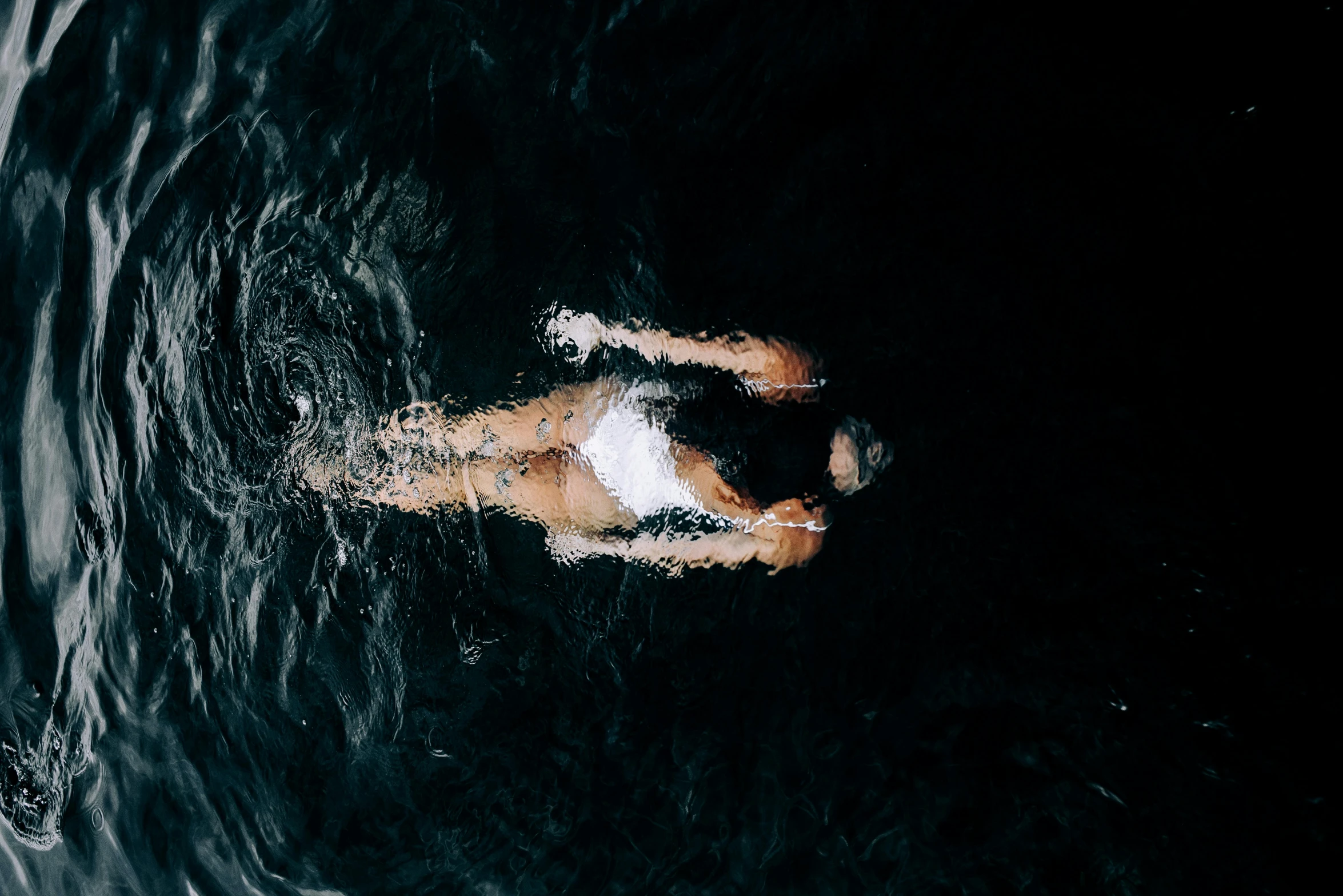 a person swimming in a body of water, inspired by Elsa Bleda, pexels contest winner, dark backround, thumbnail, high angle shot, 8k octan photo