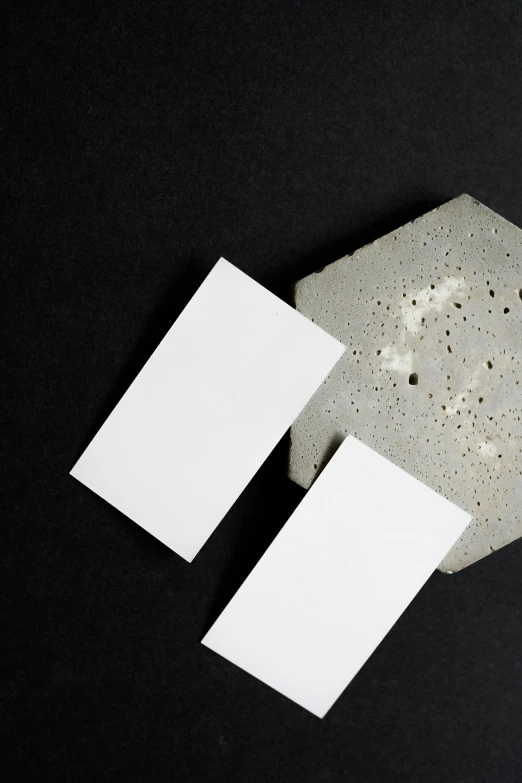 a couple of business cards sitting on top of a table, by Harvey Quaytman, trending on unsplash, postminimalism, made of cement and concrete, white ceramic shapes, 15081959 21121991 01012000 4k, large vertical blank spaces