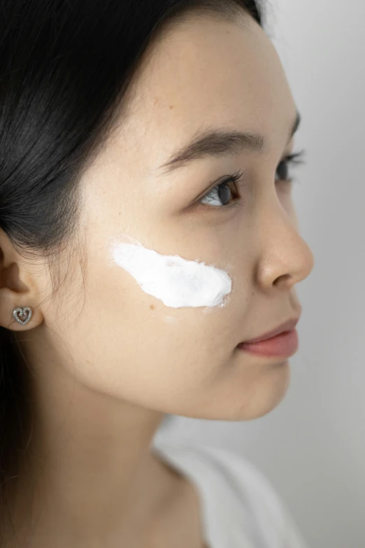 a woman with a lot of cream on her face, detailed product image, over-shoulder shot, katherine lam, detail shot