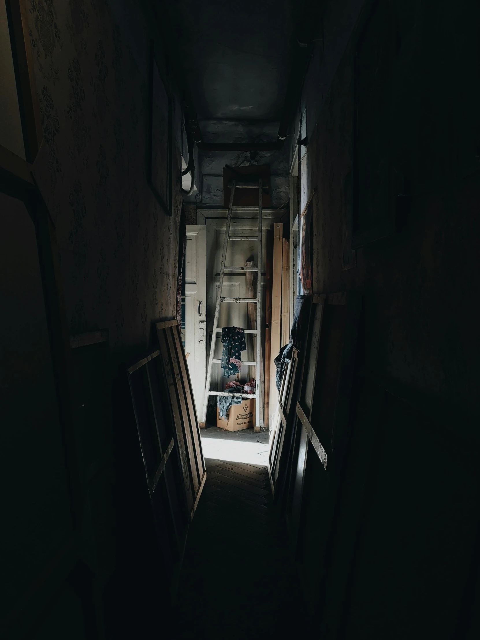 a dark hallway leading to an open door, inspired by Elsa Bleda, in a workshop, real photo, cluttered, low quality photo