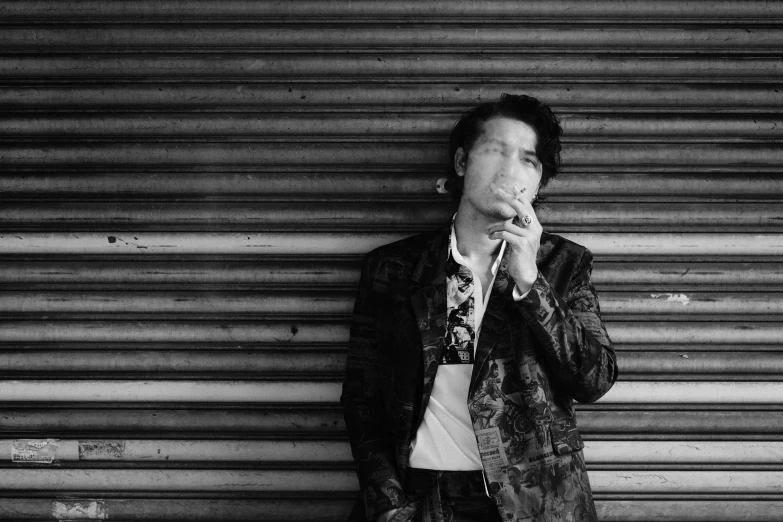 a black and white photo of a man smoking a cigarette, inspired by Justin Currie, shin hanga, wearing a fancy jacket, taking a smoke break, smoking a cigarrette🚬, press shot