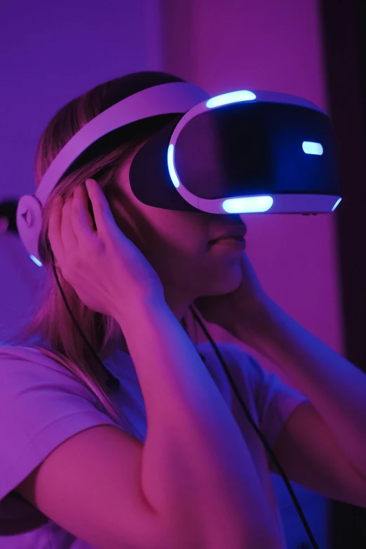 a woman wearing a virtual reality headset, inspired by Beeple, unsplash, wearing purple headphones, playstation 5, taken in the late 2010s, gaming room in 2 0 4 0