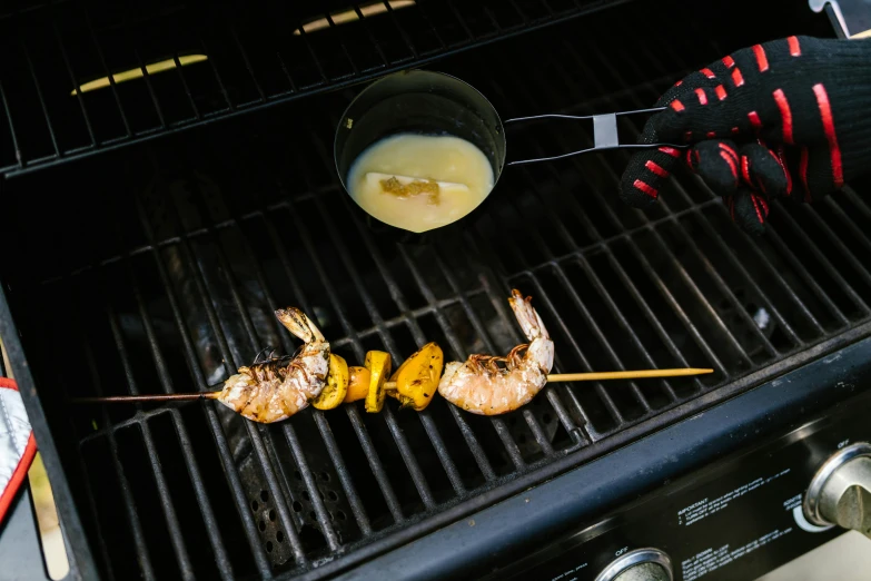 a close up of a grill with food on it, by Julia Pishtar, ghost shrimp, spatula, yellow, sleek hands