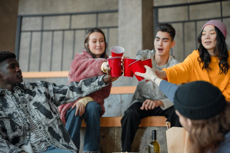 a group of people sitting around a table, trending on pexels, awkwardly holding red solo cup, holding gift, revellers, teenage boy