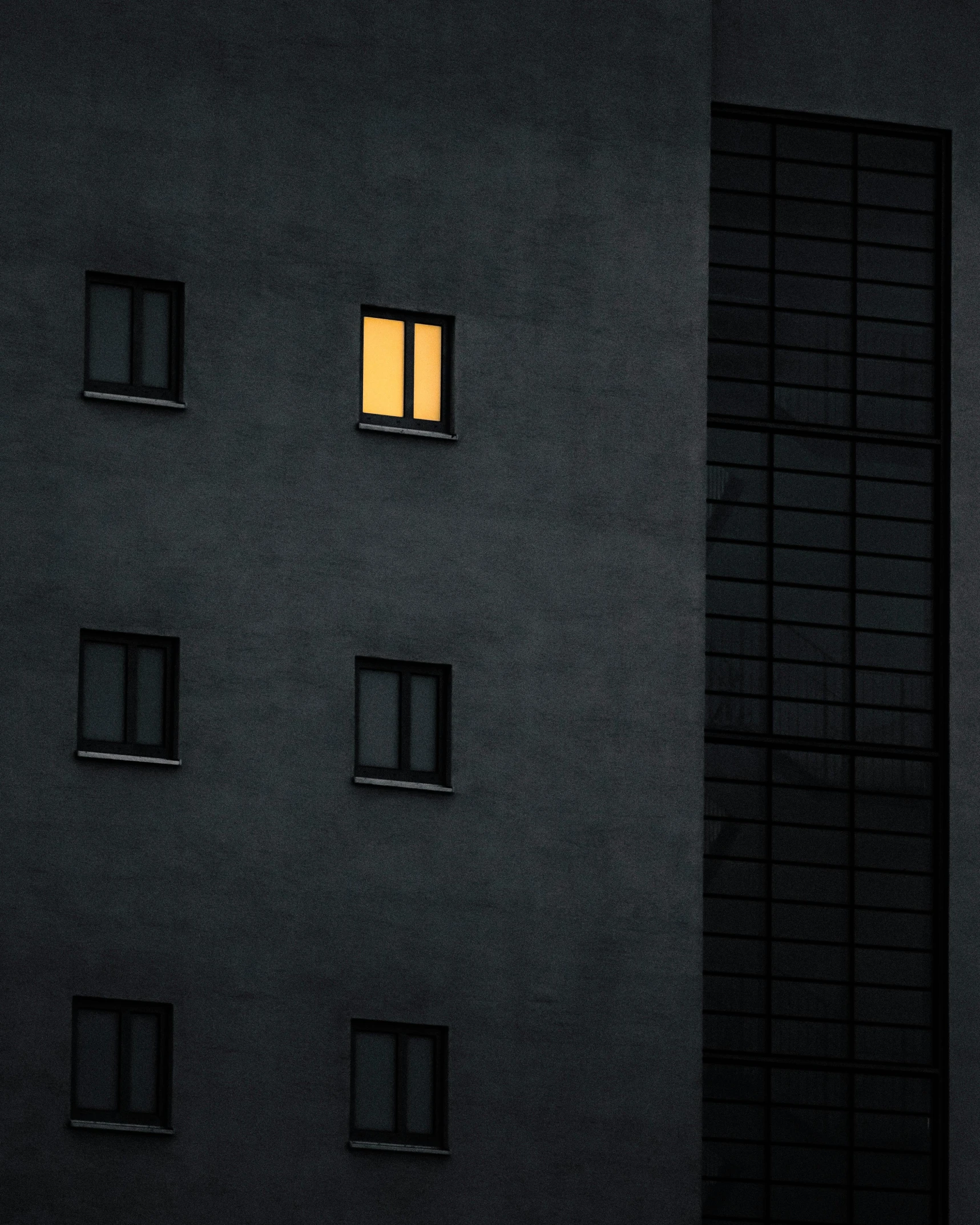 a tall building with windows lit up at night, a minimalist painting, unsplash contest winner, postminimalism, yellow light, mono eye window, ignant, natural light window