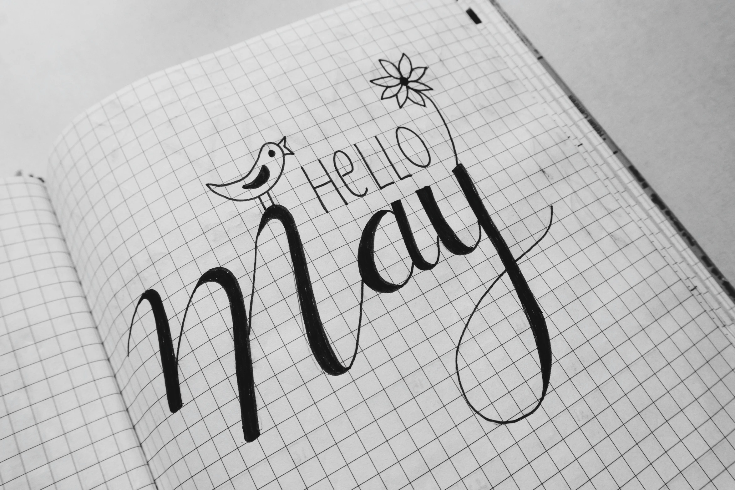 a notebook with the words hello may written on it, by Caroline Mytinger, pixabay, happening, on grey paper sketch ink style, !!beautiful!!, max bedulenko, geometric type