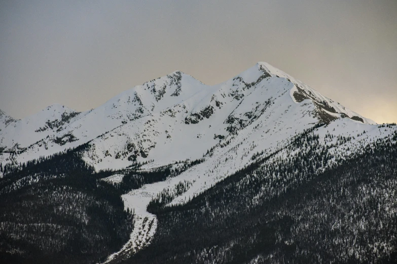 a couple of mountains that are covered in snow, by Peter Churcher, pexels contest winner, visual art, banff national park, low detail, top of the hill, slight overcast lighting