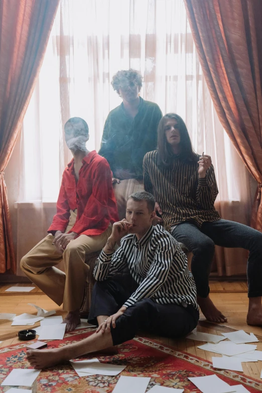 a group of people sitting on top of a living room floor, an album cover, unsplash, bauhaus, dramatic smoking pose, declan mckenna, hotel room, four legged