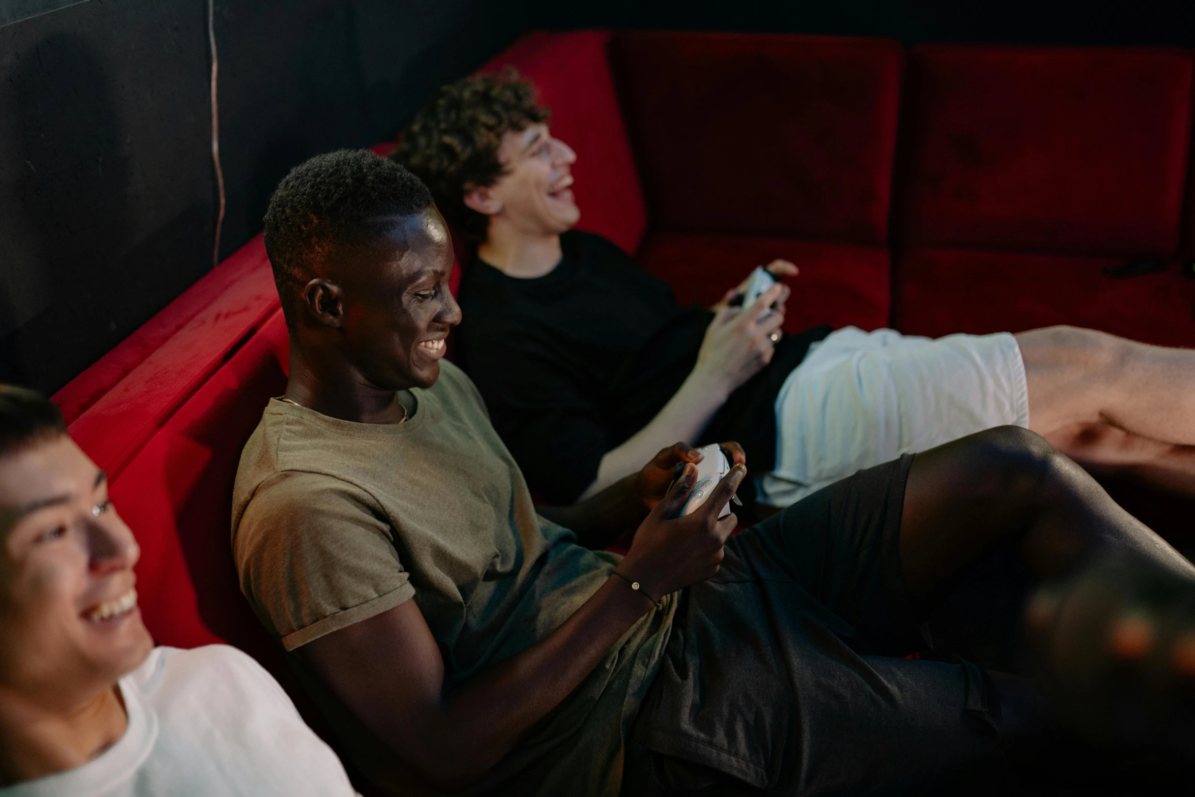 a group of men sitting on top of a red couch, pexels, happening, twins playing video games, avatar image, couple on bed, black teenage boy