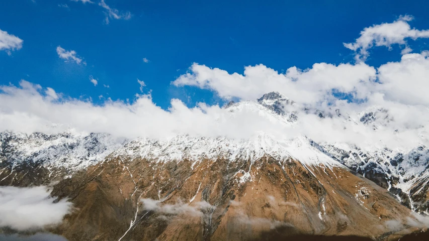 a group of people standing on top of a snow covered mountain, pexels contest winner, hurufiyya, large white clouds, himalayas, 4 k cinematic panoramic view, 2 0 0 0's photo