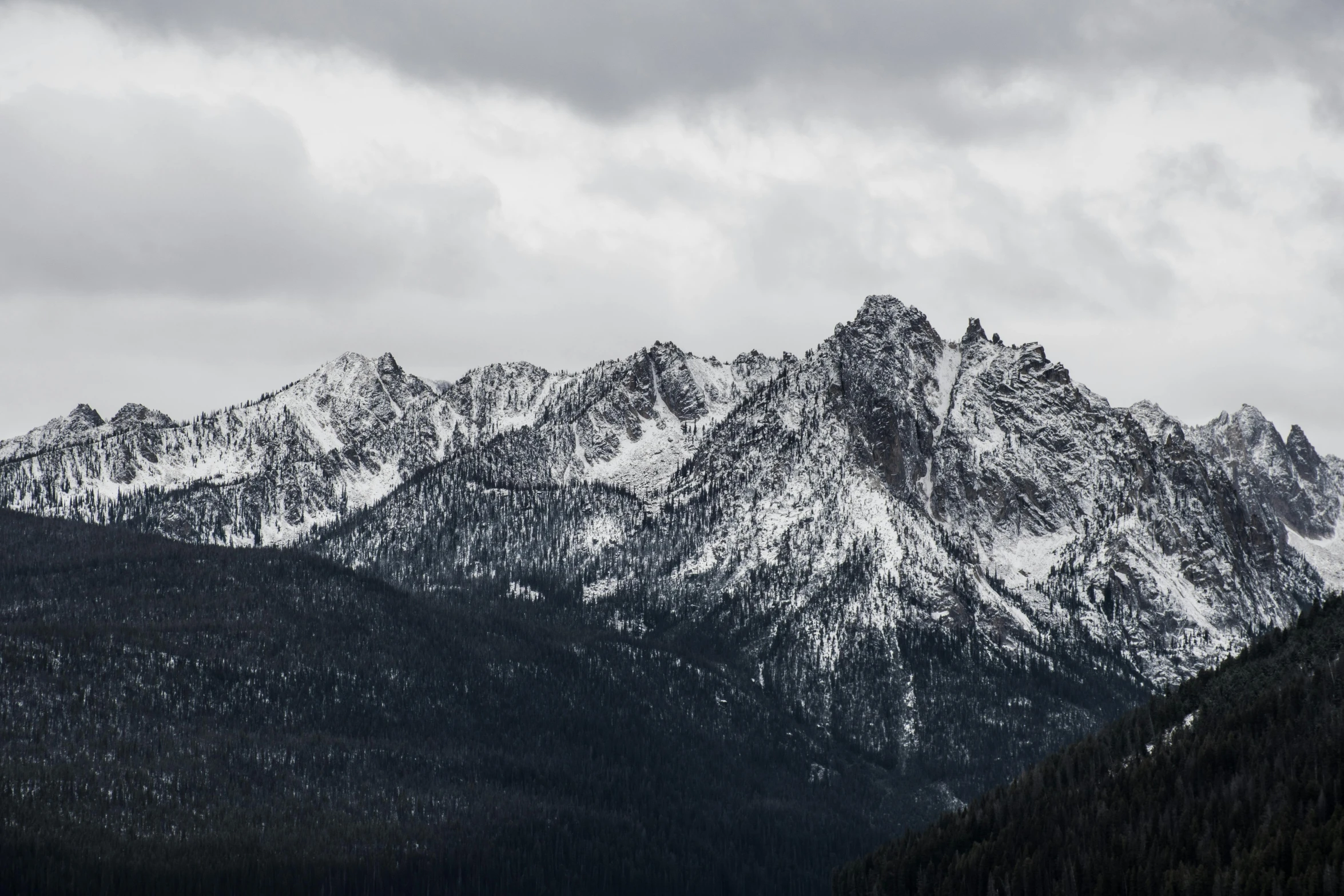 a black and white photo of a mountain range, by Matthias Weischer, pexels contest winner, overcast gray skies, washington state, snowy craggy sharp mountains, monochrome color