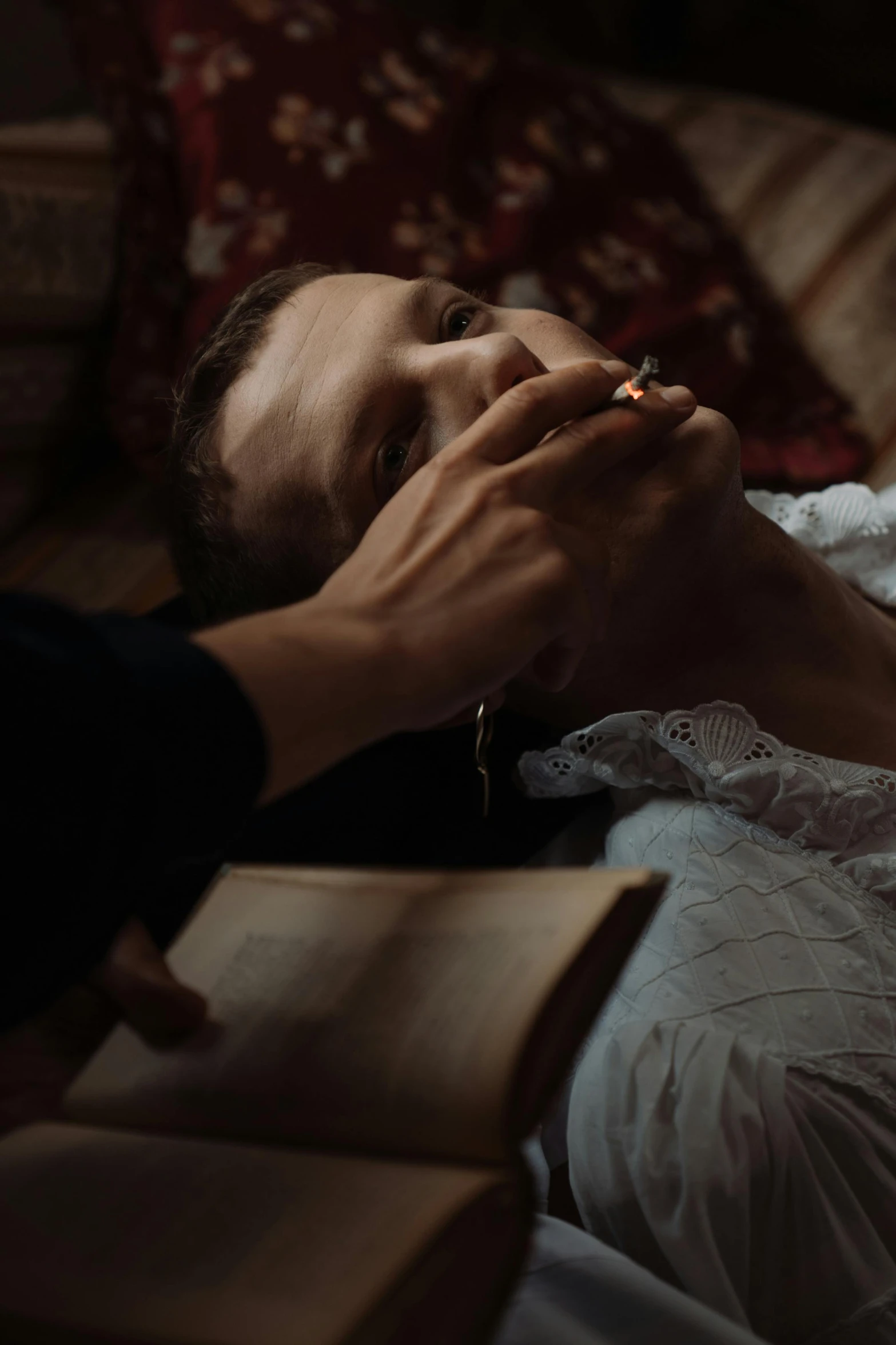 a woman laying on top of a bed next to a book, a portrait, pexels contest winner, renaissance, praying with tobacco, movie scene close up, victorian vampire, couple on bed