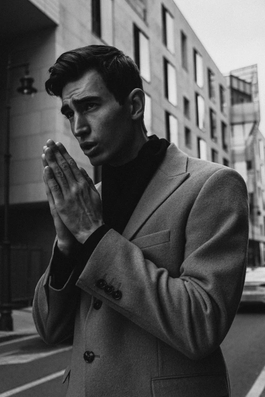 a black and white photo of a man in a suit, inspired by Jean Malouel, unsplash, photorealism, doing a prayer, robert sheehan, raf simons, handsome man