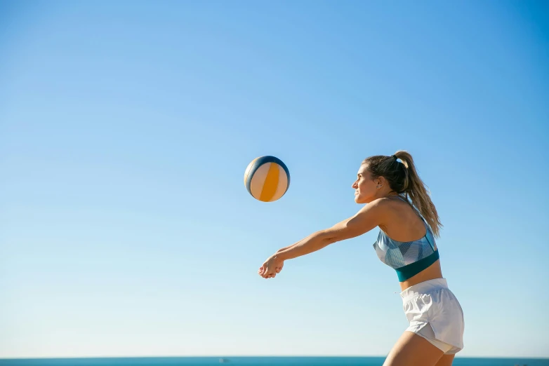 a woman is playing volleyball on the beach, a portrait, unsplash contest winner, arabesque, clear blue skies, sydney park, sport bra and dark blue shorts, circular