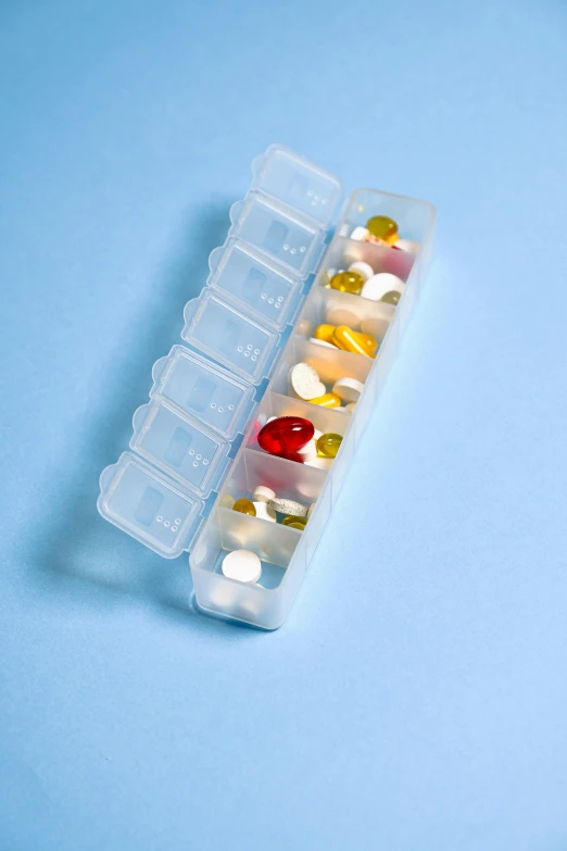 a pill case filled with assorted pills on a blue surface, pexels, plasticien, multiple stories, 2000s photo, full-body, 6 pack