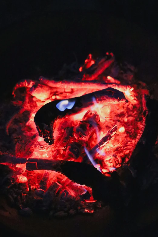 a close up of a fire in the dark, pexels contest winner, light red and deep blue mood, fire pit, infrared, red face