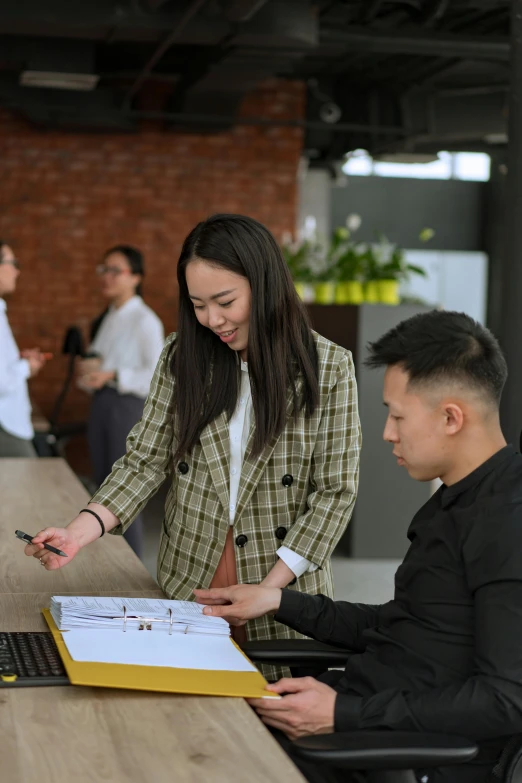 a group of people standing around a wooden table, on a desk