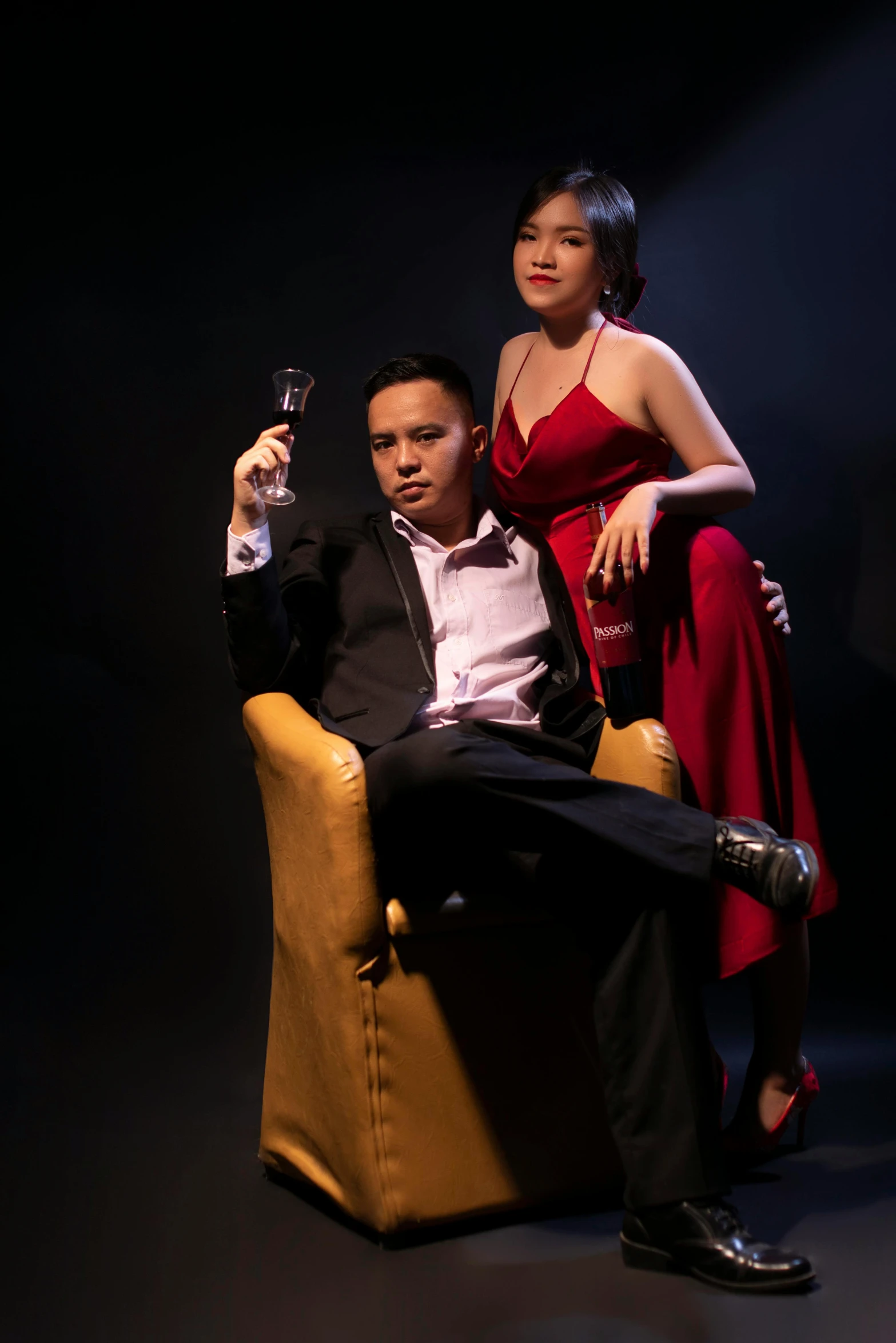 a man in a tuxedo sitting next to a woman in a red dress, inspired by Eddie Mendoza, david luong, ( ( theatrical ) ), studio photoshoot, sitting on an armchair