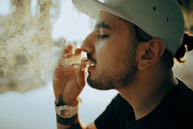 a man in a hat smokes a cigarette, trending on pexels, ganja, thumbnail, male with halo, cysts