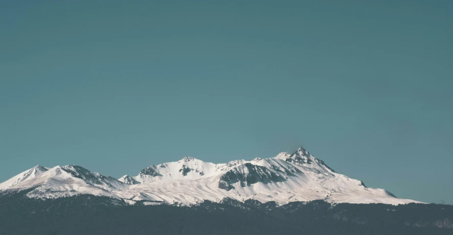 a plane flying over a snow covered mountain range, trending on unsplash, minimalism, still frame the retro twin peaks, whistler, seen from a distance, cloudless sky